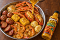 Serving suggestion: snow crab and lobster seafood boil with shrimp, eggs, potatoes, corn and sausage, garlic butter pour and Drippy Sauce bottle
